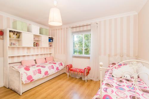 a childs bedroom with a bed and a window at Magnólia Beach House - Cascais in Cascais
