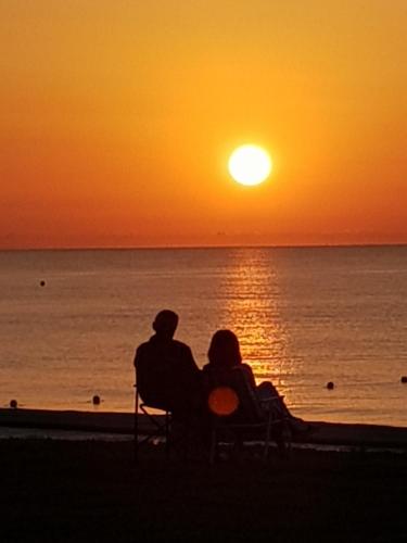 a couple sitting on a chair watching the sunset at primera linea acapulco III in Oropesa del Mar