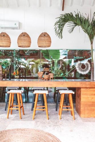 a table and stools in a room with plants at Beyond Bungalows in Canggu