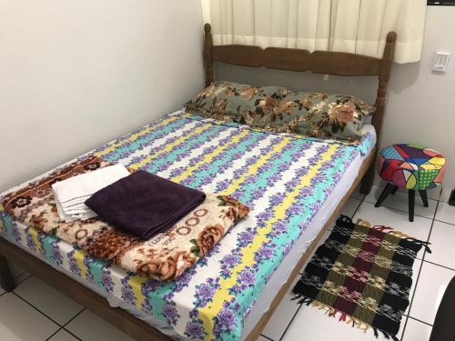 a bed with a colorful quilt on it in a room at Apto Floramar in Belo Horizonte