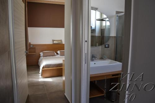 a bathroom with a bed and a sink in a room at Via Ziino 70 in Oliveri