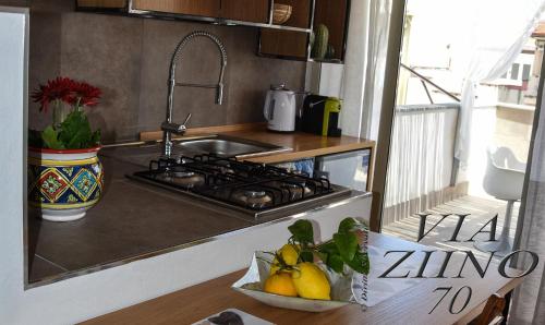 a kitchen with a stove and a bowl of fruit at Via Ziino 70 in Oliveri