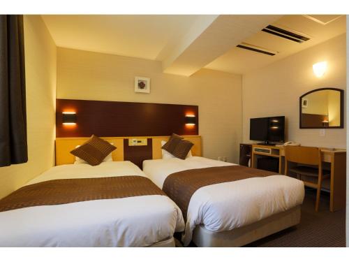 Un pat sau paturi într-o cameră la Ueno First City Hotel