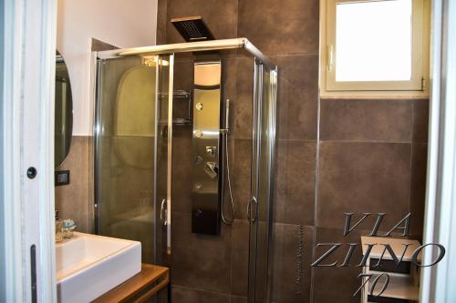 een douche met een glazen deur in de badkamer bij Via Ziino 70 in Oliveri