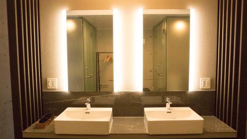 ein Badezimmer mit zwei Waschbecken und einem großen Spiegel in der Unterkunft Blue Suites Hanamuro in Zamami