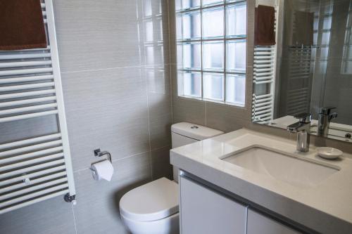 a white bathroom with a toilet and a sink at Duck Inn Mt Buller in Mount Buller