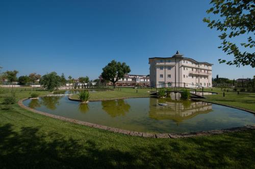a pond in a park with a building in the background at L' Araba Fenice Hotel & Resort in Altavilla Silentina