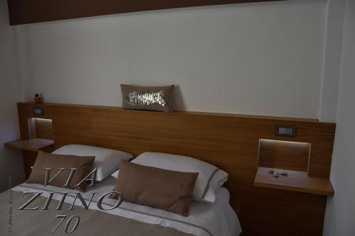 a bedroom with two beds with a wooden headboard at Via Ziino 70 in Oliveri