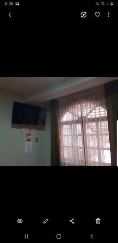 a room with a window with curtains on it at The House in Tacna