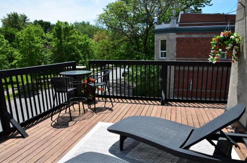 a balcony with a table and chairs on a deck at Auberge de La Fontaine in Montréal