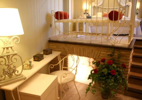 a room with a bed and a desk with a vase of flowers at Hotel Castillo de Alquézar in Alquézar