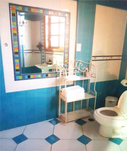 a bathroom with a toilet and a sink and a mirror at The House in Tacna