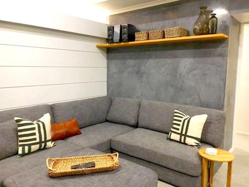 a living room with a gray couch with pillows at Mowamba F2 in Thredbo
