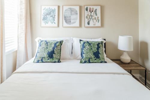 une chambre avec un lit avec des draps blancs et des oreillers dans l'établissement Spacious 2BR Apartment near Airport - Central Charming, à Dunning