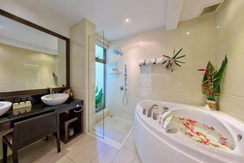 La salle de bains est pourvue d'une baignoire, de 2 lavabos et d'une douche. dans l'établissement La Lagune, à Laem Set Beach