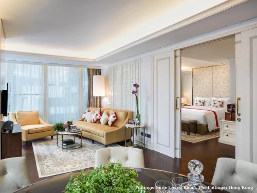 Habitación de hotel con cama y sala de estar. en The Pottinger Hong Kong, en Hong Kong