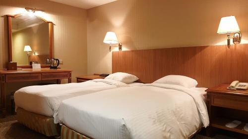 a hotel room with two beds and a mirror at Green World Flora Annex in Taipei
