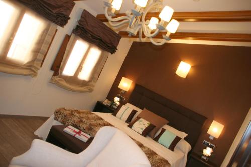 a bedroom with a large bed and a chandelier at Hotel Castillo de Alquézar in Alquézar