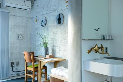 a bathroom with a table and a sink and a chair at Rc Hotel Kyoto Yasaka in Kyoto