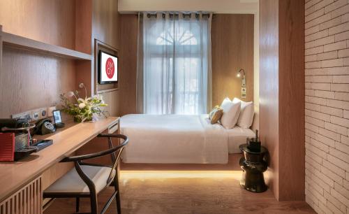 a hotel room with a bed and a desk and a window at AMOY by Far East Hospitality in Singapore