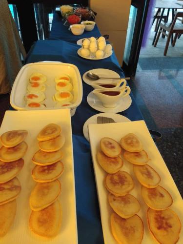 Una mesa cubierta con bandejas de comida con panqueques. en Boracay Ocean Club Beach Resort, en Boracay