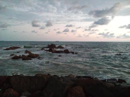 a group of rocks in the ocean under a cloudy sky at Ging View Villa in Galle