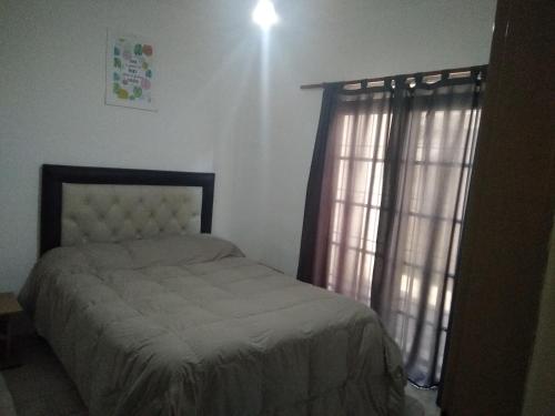 una camera da letto con un letto e una finestra di Helenita a Villa Mercedes