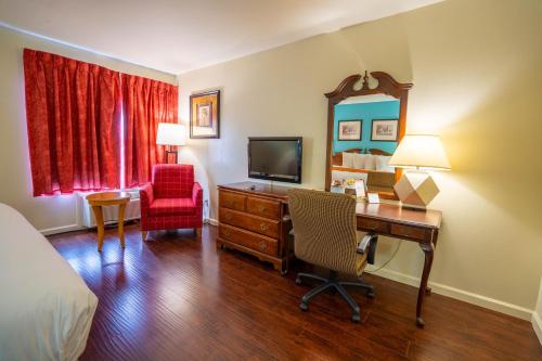 a hotel room with a desk and a television at Howard Johnson by Wyndham Buena Park in Buena Park