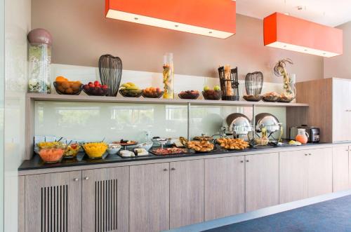 a buffet line with many different types of food at Best Western Plus Paris Saclay in Saclay