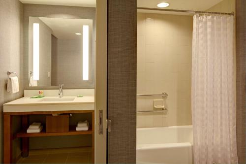 La salle de bains est pourvue d'un lavabo, d'une baignoire et d'une douche. dans l'établissement Hyatt Place Marlborough/Apex Center, à Marlborough