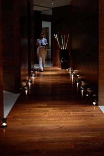 a man walking down a wooden floor with lights at Hyatt Regency Chennai in Chennai