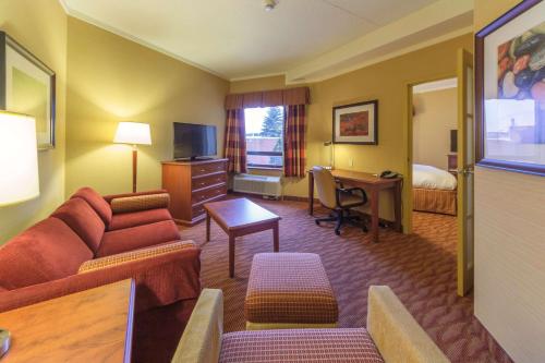 a hotel room with a couch and a desk and a bed at The Water Tower Inn - BW Premier Collection in Sault Ste. Marie