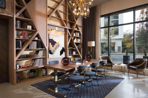 a dining room with a table and chairs and bookshelves at Thompson Nashville, by Hyatt in Nashville