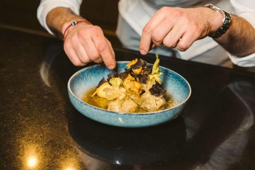 a person holding a bowl of food on a table at Grand Hyatt Berlin in Berlin
