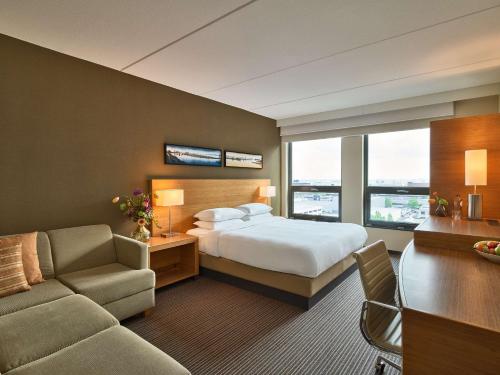 a hotel room with a bed and a couch at Hyatt Place Amsterdam Airport in Hoofddorp