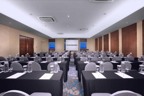 a conference room with black tables and white chairs at Harper Wahid Hasyim Medan by ASTON in Medan