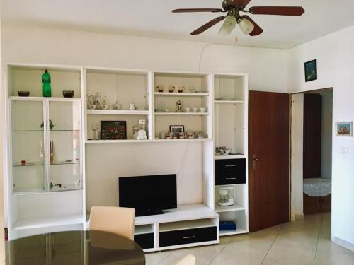 uma sala de estar com prateleiras brancas e uma televisão em Apartmani Nina em Sibenik