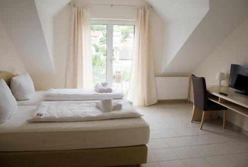 1 dormitorio con 2 camas, escritorio y ventana en Kraichtaler Hof, en Kraichtal