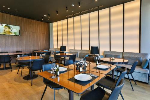 a restaurant with tables and chairs and a couch at Hotel Kalos in Budva