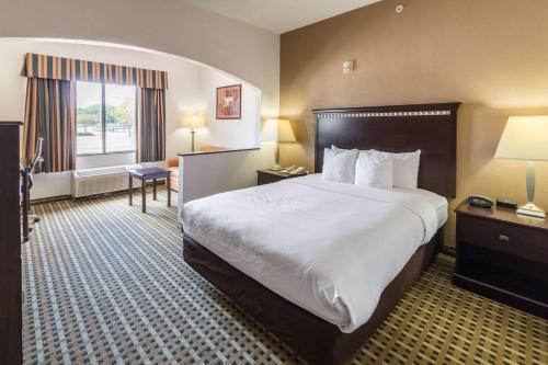 ein Hotelzimmer mit einem großen Bett und einem Fenster in der Unterkunft Quality Suites, Ft Worth Burleson in Burleson