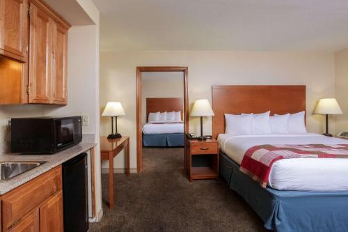 a hotel room with two beds and a television at Quality Inn Oakwood in Spokane