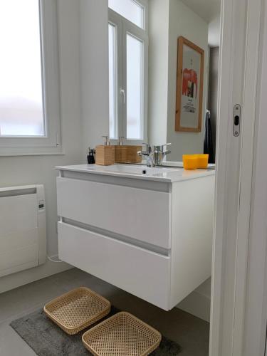 Baño blanco con lavabo y espejo en Apto Comfortable en María Pita, Centro Ciudad, en A Coruña