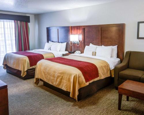 a hotel room with two beds and a chair at Comfort Inn Redding Near I-5 in Redding