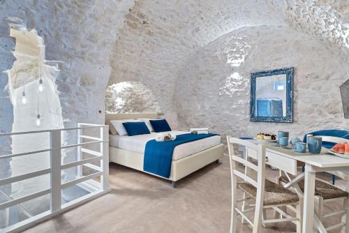 a bedroom with a bed and a table and a mirror at Azzurro Come Te - Ostuni in Ostuni