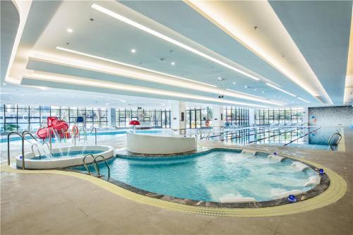 een grote kamer met een groot zwembad in een gebouw bij Howard Johnson New District Plaza ZiYang in Ziyang