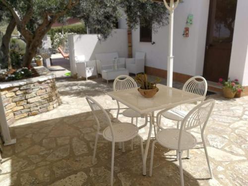 a white table and chairs in a patio at Villa Rossana in Scopello