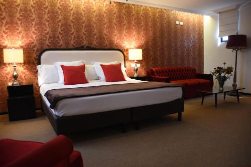 a hotel room with a bed and a red chair at Hotel Clara Luna in Xalapa