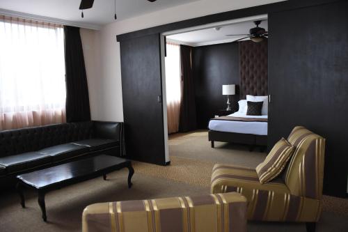 a living room with a couch and a bed in a room at Hotel Clara Luna in Xalapa