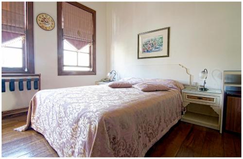a bedroom with a bed and a table and two windows at Minyon Hotel in Antalya