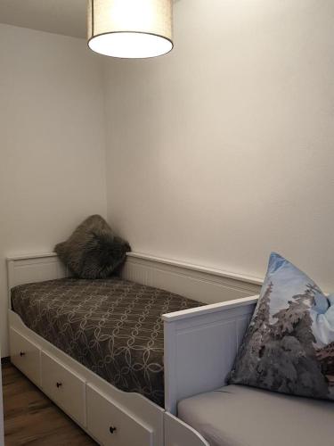 a room with a bed with a pillow and a chair at Casa Vierthaler in Scheffau am Wilden Kaiser